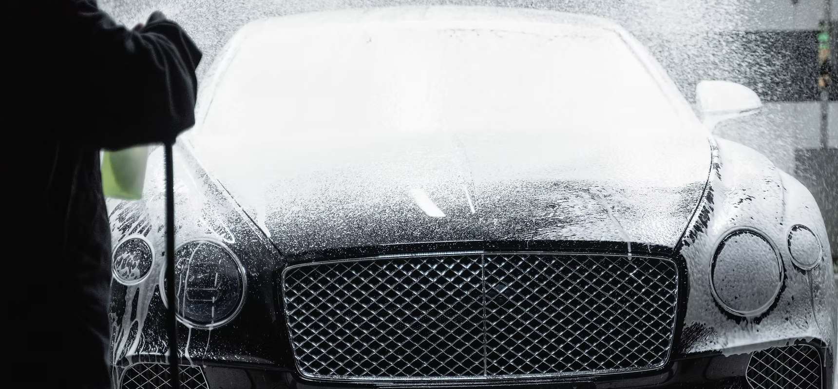car being sprayed down with car wash presoaks from mcclean car wash chemicals